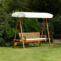 Chic Teak wooden garden swing seat with cream canopy on a lawn in a landscaped garden